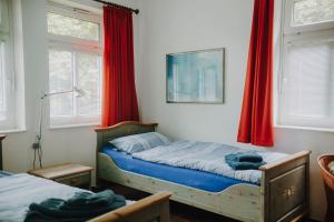 a bedroom with two beds and red curtains at Friesenpark 10 in Wurster Nordseeküste