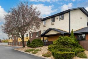 a building with a tree and bushes in front of it at Super 8 by Wyndham Hagerstown I-70 in Hagerstown