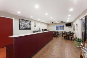 a lobby with a bar and tables and chairs at Super 8 by Wyndham Visalia in Visalia