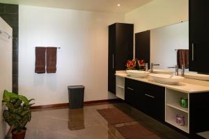 a bathroom with two sinks and a large mirror at VILLA TUPAOA in Bora Bora