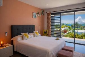 a bedroom with a large bed and a large window at VILLA TUPAOA in Bora Bora +6 photos