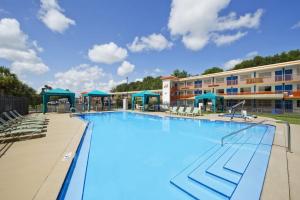 a large swimming pool with chairs and a building at Howard Johnson by Wyndham Ocala FL I-75 in Ocala