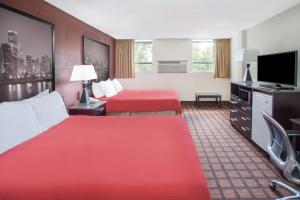 a hotel room with two beds and a flat screen tv at Super 8 by Wyndham Chicago IL in Chicago