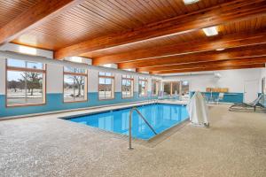 a large swimming pool in a building with wooden ceilings at Days Inn by Wyndham Imlay City in Imlay City