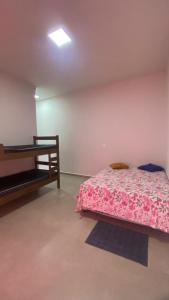 a bedroom with a bed and a table in it at Casa da Clau in Olímpia +3 photos