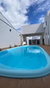 a large blue swimming pool in front of a house at Casa da Clau in Olímpia