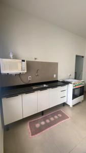 a kitchen with a counter top with a microwave at Casa da Clau in Olímpia