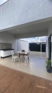 a dining room with a table and chairs in a room at Casa da Clau in Olímpia