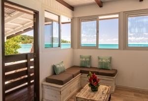 a room with a bench with windows and a table at Matira Lagoon in Bora Bora +5 photos