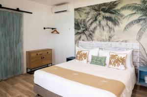 a bedroom with a white bed with a tropical wallpaper at Matira Lagoon in Bora Bora