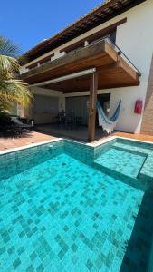 a swimming pool in front of a house at Condominio Frente Mar 3 suites com Ar Cond piscina e Hidro privativa in Mata de Sao Joao