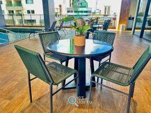 a blue table with chairs and a potted plant on it at Solaz Smart Living by 123Quarto in Tambaú