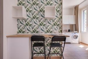 a kitchen with a table and two stools at Rooms 2Binari in Bologna