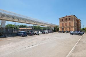 a parking lot with cars parked next to a bridge at Rooms 2Binari in Bologna