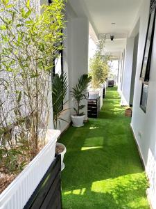 a hallway with green grass and potted plants at Aimarck Homes and Suites in Kampala