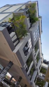 a building with palm trees on the side of it at Aimarck Homes and Suites in Kampala