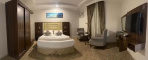 a hotel room with a bed and a flat screen tv at براون هاوس للشقق المخدومة in Quai