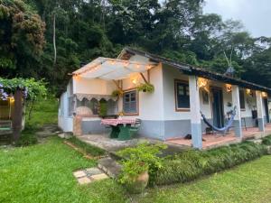 a small white house with a yard at Bocaina Sítio da Vovó in Engenheiro Paulo de Frontin