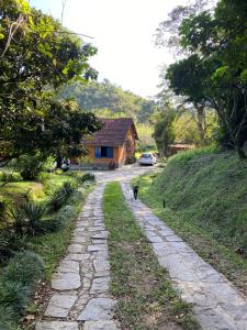 a cat walking down a stone road next to a house at Bocaina Sítio da Vovó in Engenheiro Paulo de Frontin +9 photos