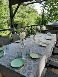 a long table with plates and vases on it at Mošķu Pirts meža māja in Turaida