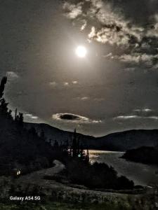 a full moon rising over a body of water at Foki Beach House in Fiskardo
