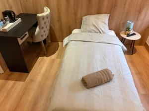 a bed in a room with a desk and a chair at Hôtel Le Normandie in Le Mans