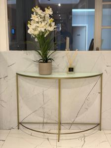a table with a vase of flowers on top of it at Hôtel Le Normandie in Le Mans