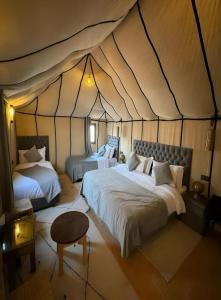 a bedroom with two beds in a tent at Merzouga Dream Camp in Merzouga