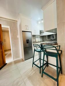 a kitchen with two chairs and a refrigerator at Legae la rena in Polokwane