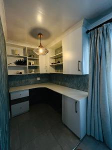 a home office with a desk and a curtain at Legae la rena in Polokwane +7 photos