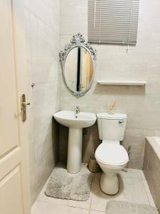 a bathroom with a toilet and a sink and a mirror at Legae la rena in Polokwane