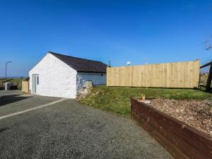 a house with a wooden fence next to a road at The Studio in Caernarfon