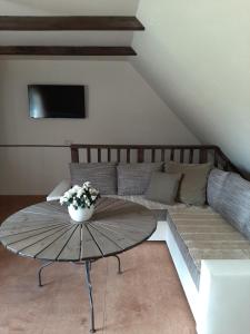 a living room with a table and a couch at Mošķu Pirts meža māja in Turaida
