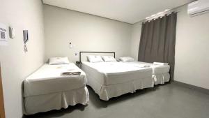 una stanza con due letti in una stanza d'ospedale di Hotel Fly - Aeroporto Cuiabá a Várzea Grande
