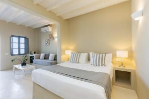 a bedroom with a large white bed and a couch at Carpe Diem Santorini in Pyrgos +58 photos