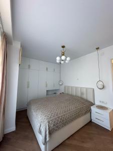 a white bedroom with a bed and a ceiling at Wine Láà apartamento in Maison Henou