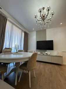 a living room with a dining table and a chandelier at Wine Láà apartamento in Maison Henou