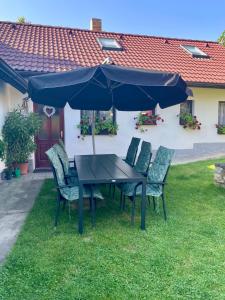 a table and chairs under an umbrella in a yard at Chalupa u Pepy in Tábor