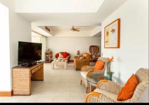 a living room with a flat screen tv and furniture at Bay View Grand Ixtapa Exclusive in Ixtapa