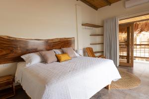 a bedroom with a white bed with a wooden headboard at Casa Barú in Barú