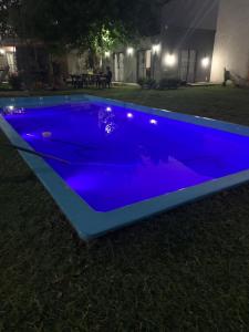 a blue swimming pool with lights on the grass at Las catalinas in General Rodríguez