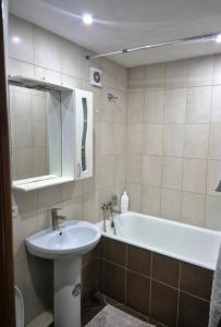 a bathroom with a sink and a bath tub at Apartament Balti in Bălţi