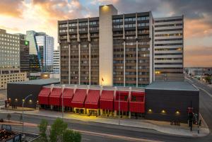 a large building with red awnings in a city at Ramada Plaza by Wyndham Regina Downtown in Regina