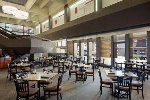 a restaurant with tables and chairs and windows at Ramada Plaza by Wyndham Regina Downtown in Regina