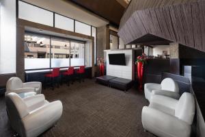 a waiting room with white chairs and a television at Ramada Plaza by Wyndham Regina Downtown in Regina