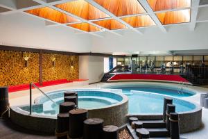 a large swimming pool in a building with a large ceiling at Ramada Plaza by Wyndham Regina Downtown in Regina