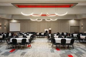 a conference room with tables and chairs and a screen at Ramada Plaza by Wyndham Regina Downtown in Regina +131 photos