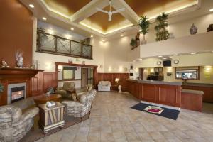 a large living room with a fireplace and a kitchen at Super 8 by Wyndham Fort St. John BC in Fort Saint John