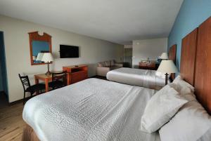 a hotel room with two beds and a desk at Days Inn & Suites by Wyndham Thibodaux in Thibodaux +56 photos