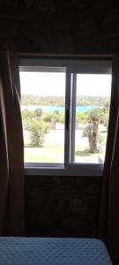 a bedroom window with a view of a palm tree at Balcon al dique in Las Chacras